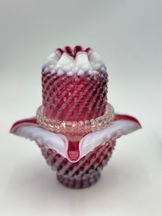 a red and white glass object on top of a table