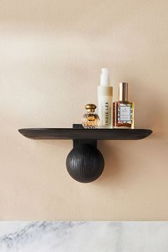 a shelf with some bottles and other items on it next to a marble counter top