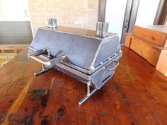 a large metal grill sitting on top of a wooden table