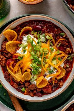 a bowl filled with chili and cheese on top of a table