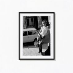 a black and white photo of a man holding a skateboard