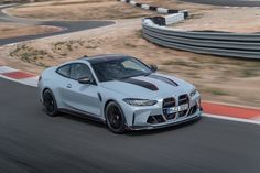 a white sports car driving on a race track