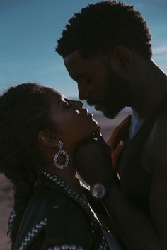 a man and woman kissing each other in the desert