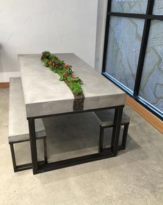 a concrete table with plants on it in front of a window