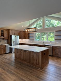 a large kitchen with wooden cabinets and white counter tops, an island in the middle