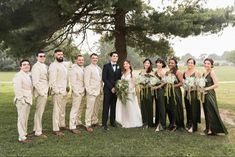 a group of people standing next to each other in front of a tree