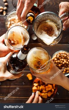 four people toasting with beer and nuts