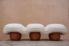 two white benches sitting on top of each other in front of a beige wall and floor