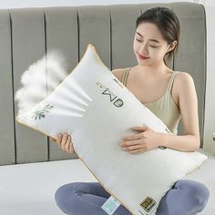 a woman sitting on the floor holding a pillow