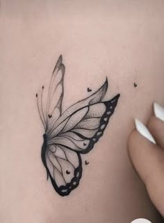 a woman's stomach with a black and white butterfly tattoo on the side of her belly