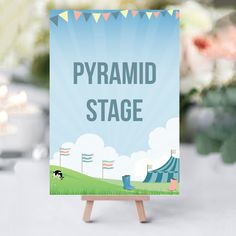 a sign that says pyramid stage on it in front of a table with flowers and candles