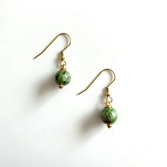 Green Cloissone earrings. 10mm. These earrings dangle from gold plated ear wires Everyday Green Lever Back Earrings, Gold Beaded Dangle Earrings With French Hook, Gold Beaded Earrings With French Hook As Gift, Green Lever Back Earrings As A Gift, Nickel-free Yellow Gold Round Bead Earrings, Gold Jewelry With French Hook And Round Beads, Gold Hypoallergenic Round Bead Earrings, Gold Hypoallergenic Earrings With Round Beads, Gold Hypoallergenic Earrings