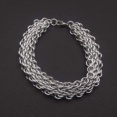 a silver chain bracelet on a black background