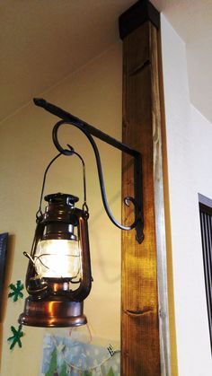 an old fashioned light hanging from the side of a wall