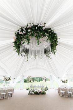 the inside of a white tent with tables and chairs set up for a wedding reception