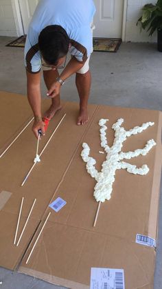 a man is working on something made out of marshmallows