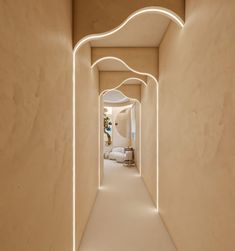 the hallway is lit up with white lights and an arch between two walls that lead to another room