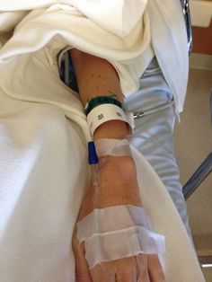 a person in a hospital bed with an iv tube wrapped around their arm and hand