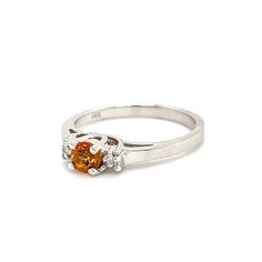 This beautiful 14K white gold ring brings all of the attention to its centerpiece, a 4mm round-cut citrine. The citrine is highlighted by a brilliant round-cut diamond on each side. 14K White Gold Citrine: Round-cut, 4x4mm Diamond: 2 Round-cut Finger Size: 6.75 Orange Topaz Ring With Prong Setting For Promise, Classic Orange Topaz Ring With Prong Setting, Elegant Orange Sapphire Round Ring, Classic Round Topaz Birthstone Ring, Elegant Orange Solitaire Rings, Classic Round Cut Topaz Birthstone Ring, Classic Topaz Birthstone Ring With Center Stone, Orange Diamond Ring With Prong Setting, Orange Diamond Topaz Ring With Center Stone