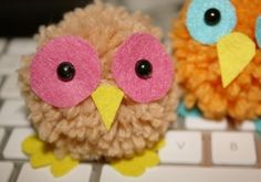 two small stuffed animals sitting on top of a computer keyboard, one is orange and the other is brown