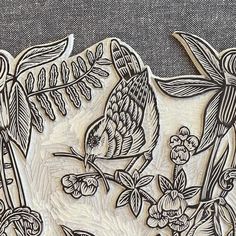 an intricately carved wooden plaque with birds and flowers