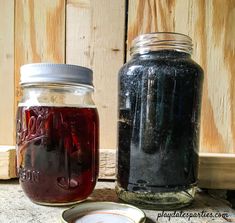 two jars filled with liquid sitting next to each other