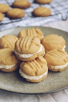 some cookies are sitting on a plate with white frosting and peanut butter in the middle