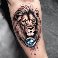 a man's arm with a lion tattoo on it and a crystal ball in the middle