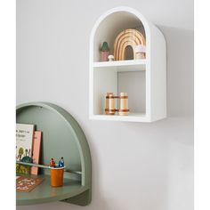 a white shelf with books and toys on it next to a wall mounted bookcase