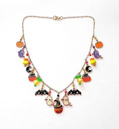 This happy and colorful Halloween charm necklace is handcrafted by myself and a one of a kind original.  The gold plated chain is 20 inches long with 17 drops containing  pumpkins, jack o lanterns, candy corn,  moons, bats and lots of crystals so it sparkles as you move.  It contains an assortment of enamel charms, glass, acrylic and crystals.  If you need it shorter or longer just let me know, and I will adjust it to as close as possible to the size you desire. If you would like a charm switche Whimsical Handmade Multicolor Charm Necklaces, Themed Handmade Gold Necklaces, Handmade Multicolor Novelty Jewelry, Handmade Costume Jewelry For Halloween, Playful Handmade Gold Charm Necklaces, Playful Handmade Gold Charm Necklace, Unique Handmade Halloween Necklaces, Fun Multicolor Halloween Jewelry, Themed Handmade Multicolor Necklace