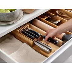 the drawers are open to show utensils and other kitchen items in it,