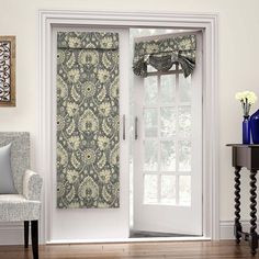 a living room with a white door and blue patterned curtains on the window sill