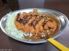 a silver plate topped with rice and meat