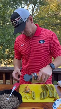 a man in red shirt preparing food on table