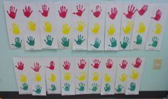 several handprints are displayed on the wall in front of children's hands