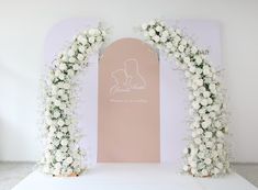 a wedding arch decorated with white flowers and greenery