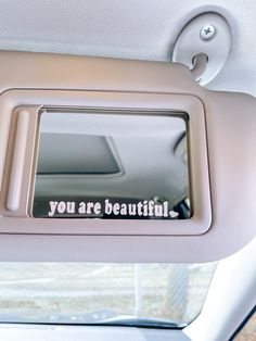 you are beautiful written on the side mirror of a car's dash board,