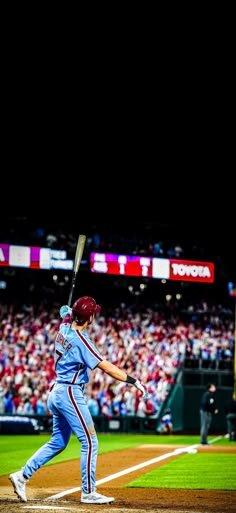 a baseball player holding a bat on top of a field in front of a crowd