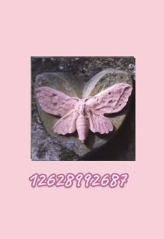 a pink butterfly sitting on top of a heart shaped rock with the word love written below it