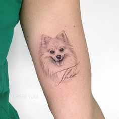 a woman's arm with a small tattoo of a dog