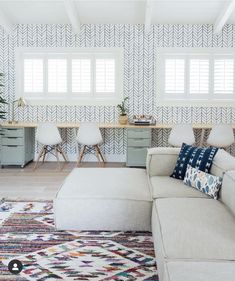 a living room filled with furniture and a large white sectional couch in front of a window