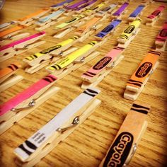 several wooden crayons are lined up on a table with name tags attached to them