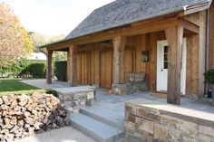 a house with wood stacked on the front porch and steps leading up to it's entrance