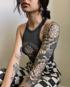 a woman with tattoos sitting on the floor