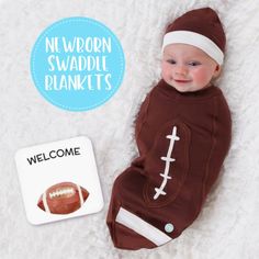 a baby in a football outfit laying next to a welcome sign with a football on it