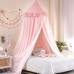 a pink canopy bed with white sheets and pillows in a girls's bedroom decorated for valentine's day