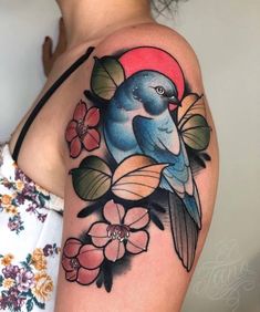 a blue bird sitting on top of a branch with flowers