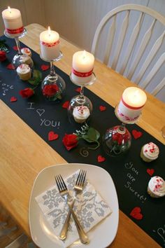 a valentine's day table setting with candles and napkins