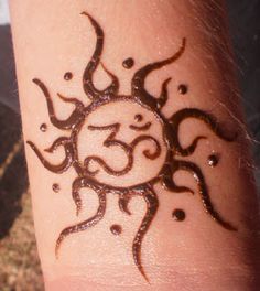 a sun tattoo on someone's wrist that has the number three drawn on it