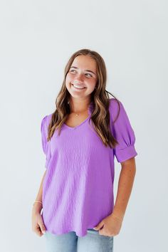 Indulge in the vibrant and joyful energy of Amy In Purple. The ruffle v-neck and banded sleeves add a playful touch to this elegant design. With its stunning purple hue, this piece is sure to brighten up your wardrobe and your day. Fits true to size. Model is wearing a small and is 5'3". Model in try on video is wearing a 2X and is 5'11". Size Chart Length Bust S 24" 38" M 24" 40" L 25" 42" 1x 26" 46" 2x 27" 48" 3x 27" 52" *All measurements are approximate and done while hanging.* Fabric and Car Day Fits, July 4th Sale, Tiered Dresses, Teen Dress, Hanging Fabric, Spring Fits, Purple Hues, White Outfits, Floral Maxi Dress